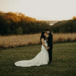 Maidenwood-events-and-weddings-bride-and-groom-embrace-with-scenic-background