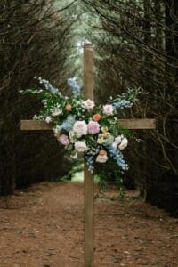 Beautiful colorful floral on a cross arch at our forest wedding venues Spring wedding